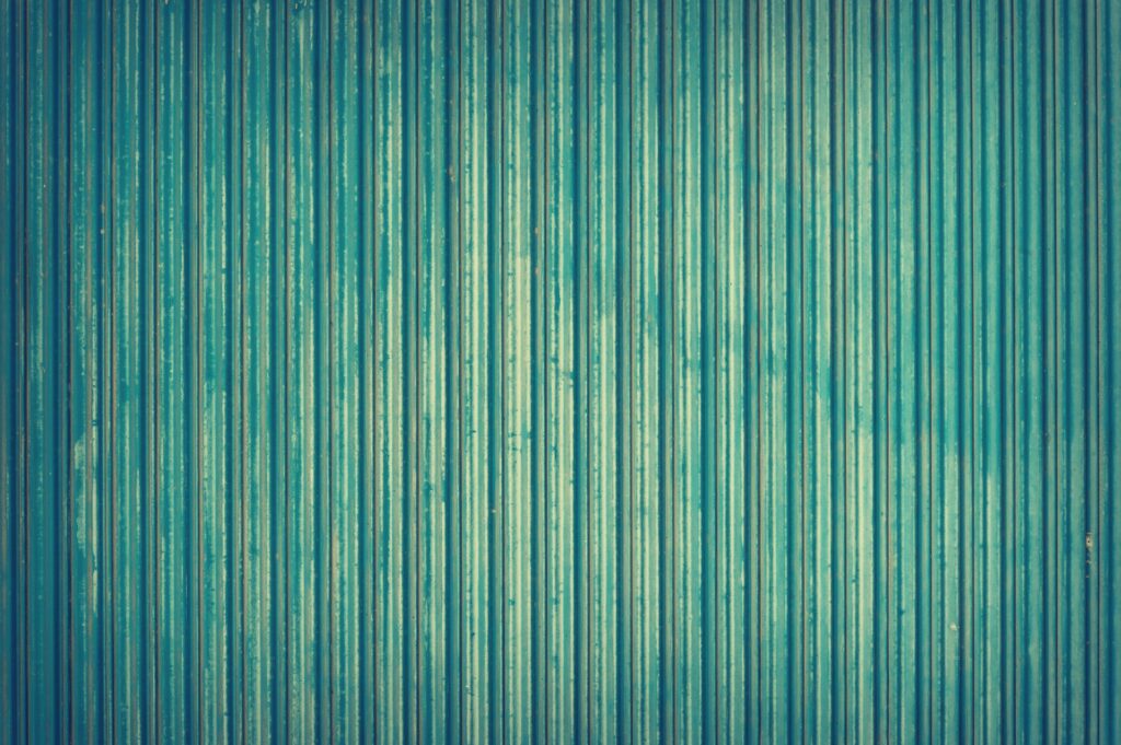 Detailed view of blue corrugated metal texture for industrial backgrounds.