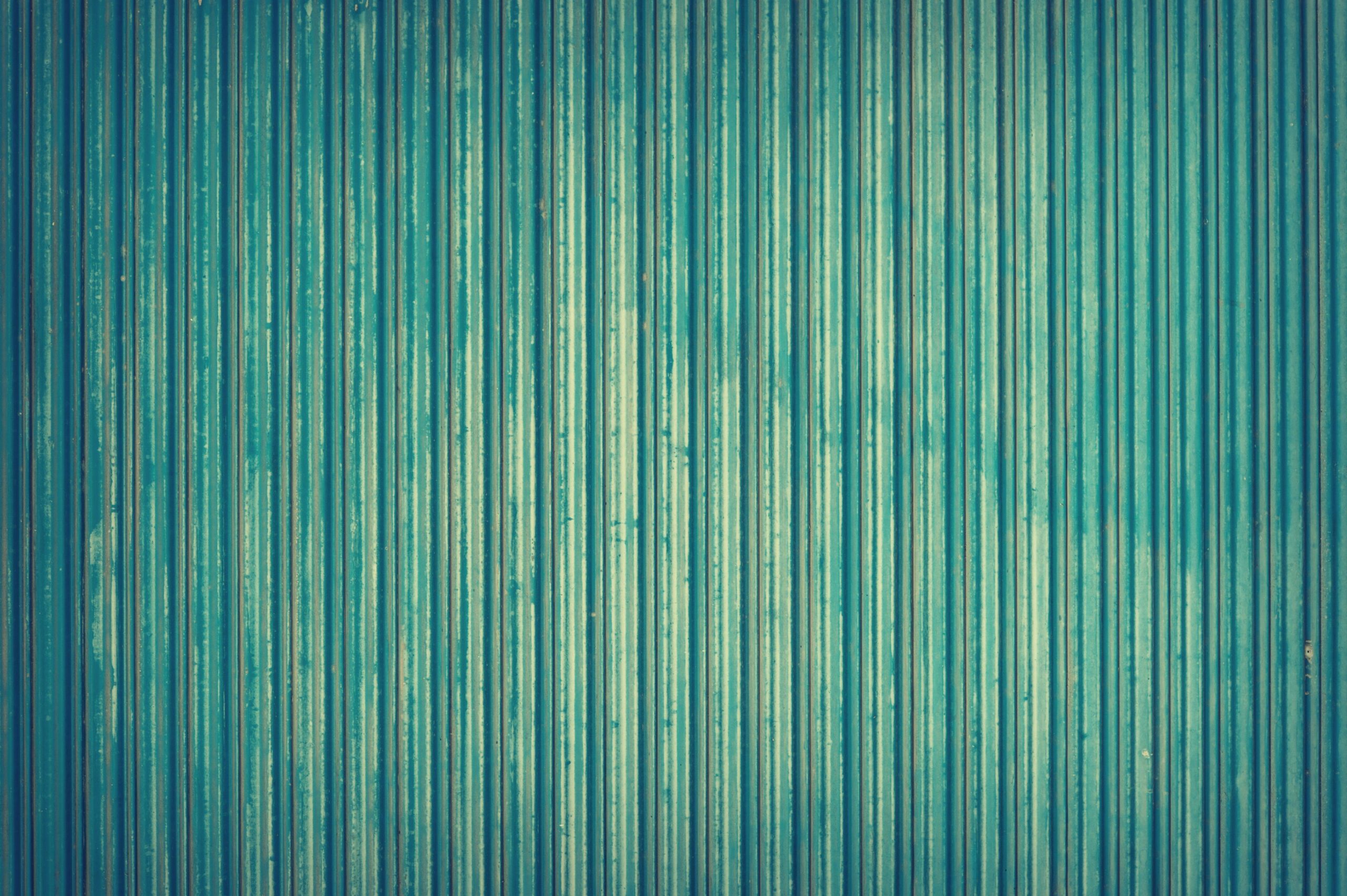 Detailed view of blue corrugated metal texture for industrial backgrounds.